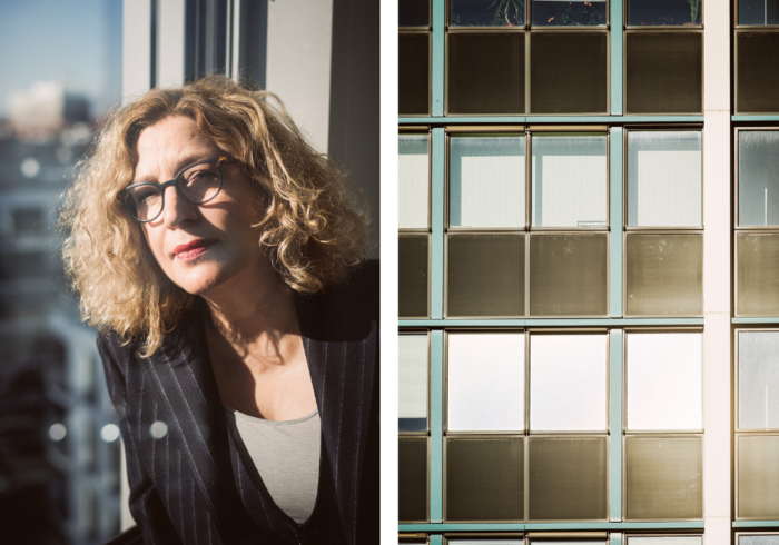 Das Bild ist in zwei Hälften geteilt. Links ist eine Frau mit lockigem blondem Haar und Brille zu sehen, die nachdenklich aus einem Fenster blickt. Sie trägt einen Blazer. Rechts ist eine Fassade mit vielen Fenstern abgebildet.
