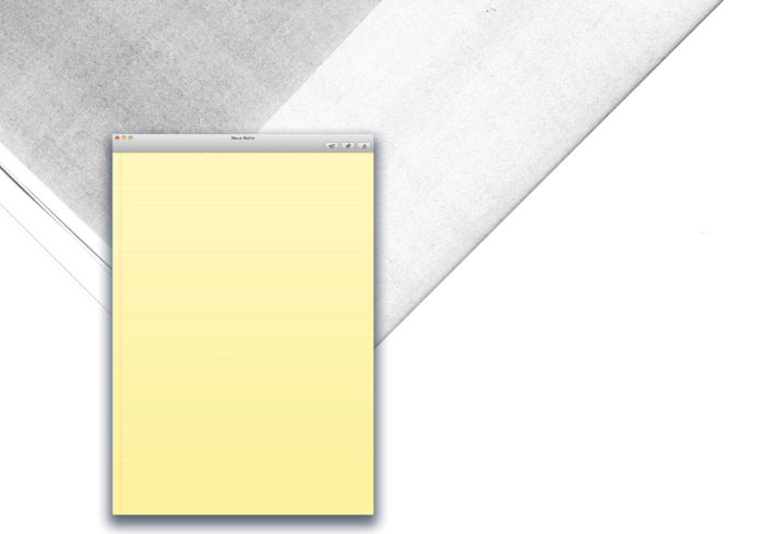 Ein Notizblock mit gelben Blättern liegt auf einem dunklen Schreibtisch. Auf dem Bildschirm eines Computers ist ein leeres Textdokument geöffnet.