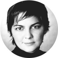 Schwarz-Weiß Porträt einer jungen Frau. Sie hat kurze, dunkle Haare und blickt direkt in die Kamera. Ihr Gesichtsausdruck wirkt ernst und nachdenklich.