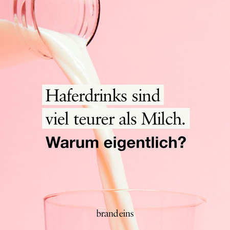 Das Bild zeigt einen rosafarbenen Hintergrund. Im Vordergrund ist ein Glas mit einem Haferdrink zu sehen, in das ein Strohhalm gesteckt ist. Der Drink wird gerade eingegossen. Über dem Glas steht in schwarzer Schrift die Frage: "Haferdrinks sind viel teurer als Milch. Warum eigentlich?".