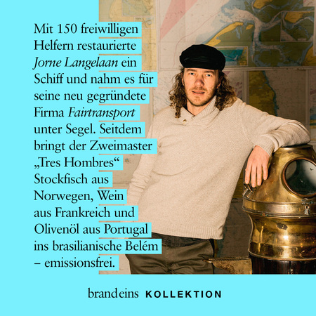 Ein Mann mittleren Alters mit braunen Haaren und Bart lächelt freundlich in die Kamera. Er trägt ein kariertes Hemd und eine dunkle Jacke und steht an Bord eines Schiffes, möglicherweise auf der Brücke. Im Hintergrund ist eine Seekarte zu sehen. Das Bild vermittelt einen Eindruck von Abenteuer und Nachhaltigkeit, da der Text auf dem Bild von einem emissionsfreien Transport mit dem Segelschiff "Tres Hombres" spricht.