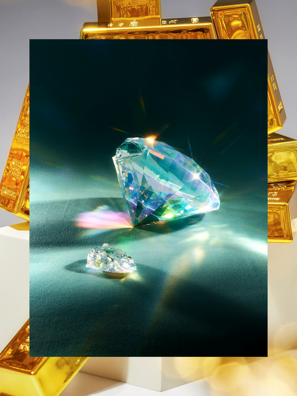 Ein großer, funkelnder Diamant steht im Mittelpunkt des Bildes, umgeben von mehreren Goldbarren. Der Diamant reflektiert Licht in allen Farben des Regenbogens und erzeugt einen hellen Schein. Die Szene wirkt luxuriös und vermittelt ein Gefühl von Reichtum und Wert.
