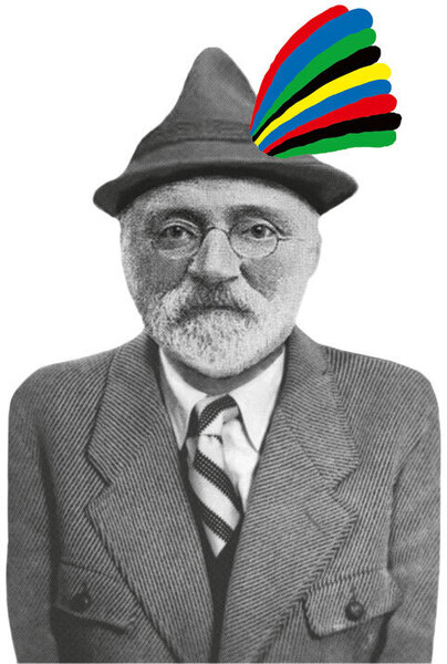 Ein älterer Mann mit Bart und Hut, der ernst dreinblickt. Auf seinem Hut befindet sich ein farbiges Band in den Farben Rot, Gelb, Grün, Blau, Schwarz und Weiß. Es handelt sich um ein Schwarz-Weiß-Porträt.