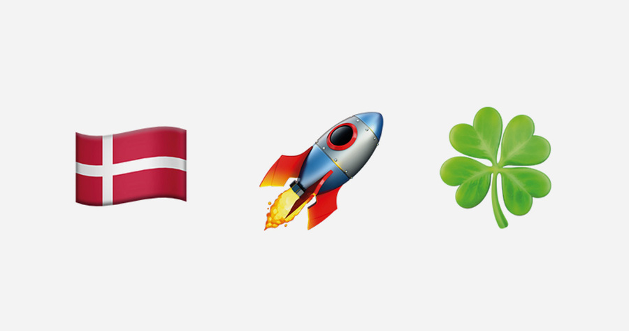 Das Bild zeigt drei Symbole nebeneinander: Die dänische Flagge, eine Rakete mit Flammen und ein grünes Kleeblatt. Die Symbole stehen für Glück und Erfolg in Dänemark.