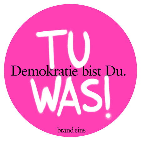Grafik mit einem pinkfarbenen Kreis auf weißem Hintergrund. Im Kreis steht in großen, weißen Buchstaben "TU WAS!". Darunter steht in kleinerer Schrift "Demokratie bist Du.". Unten rechts befindet sich das Logo "brand eins".