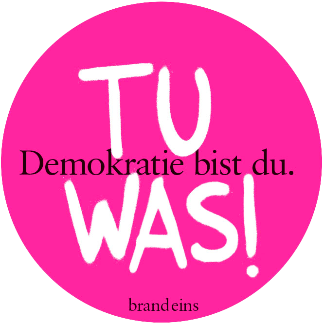 Das Bild zeigt einen rosafarbenen Kreis mit weißem Text darauf. Der Text ist in einer Fremdsprache verfasst und scheint eine politische Aussage oder ein Slogan zu sein. Der Satz "Demokratie bist du was!" steht in der Mitte des Kreises, während "brandeins" am unteren Rand geschrieben steht. Das Bild ist für alle Nutzer zugänglich, auch für Menschen mit Sehbehinderungen, und entspricht den EAA-Richtlinien für die Zugänglichkeit von Websites.