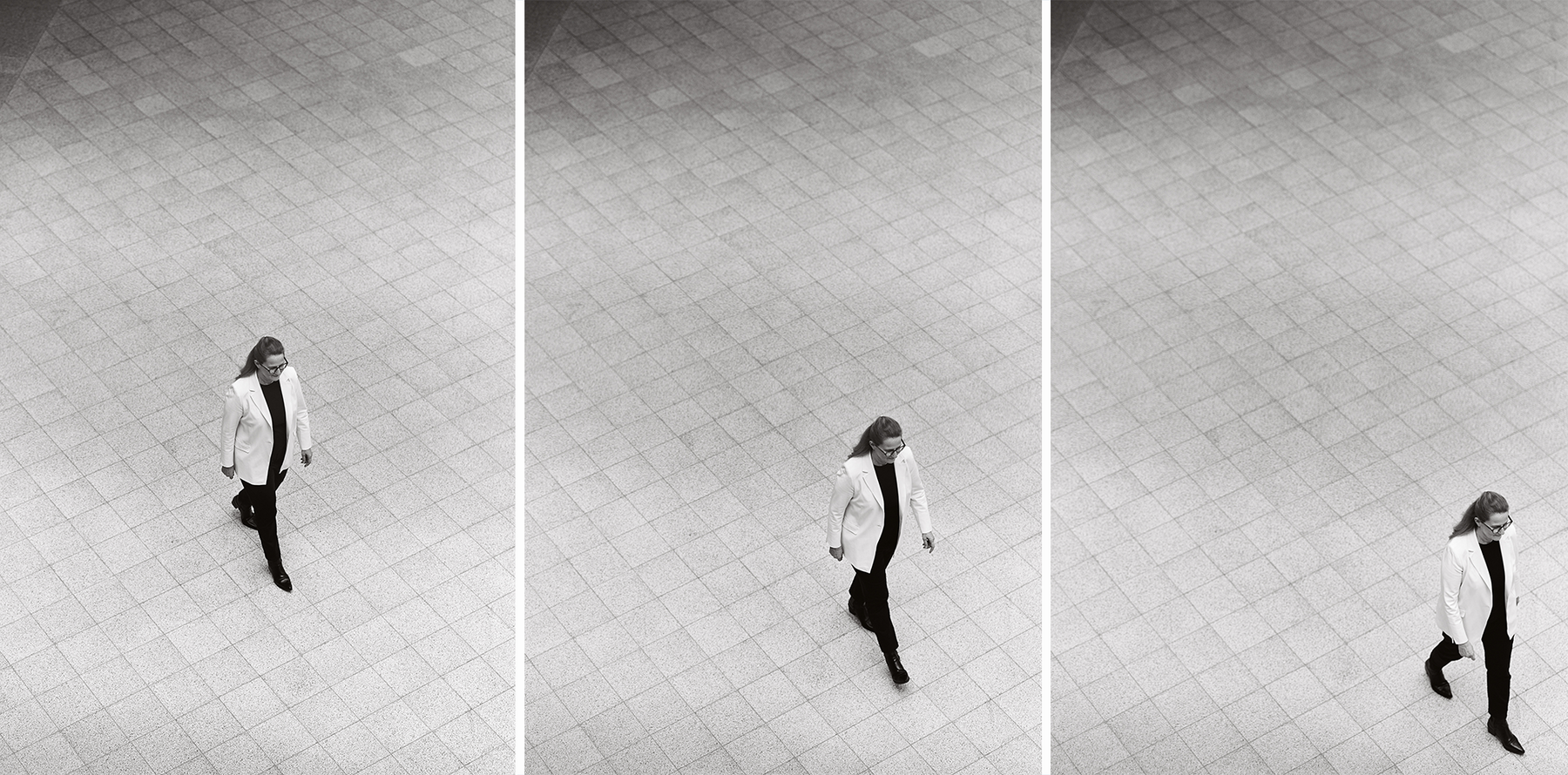 Bei dem Bild handelt es sich um eine Schwarz-Weiß-Collage aus drei Fotografien, die eine Frau zeigen, die auf einem gefliesten Boden geht. Die Frau trägt einen weißen Mantel und eine schwarze Hose, und ihre Position und Bewegung sind in verschiedenen Bildern festgehalten. Die Collage ist so gestaltet, dass sie für ein breites Publikum, einschließlich sehbehinderter Personen, zugänglich ist, da sie eine klare und übersichtliche Darstellung des Themas bietet.