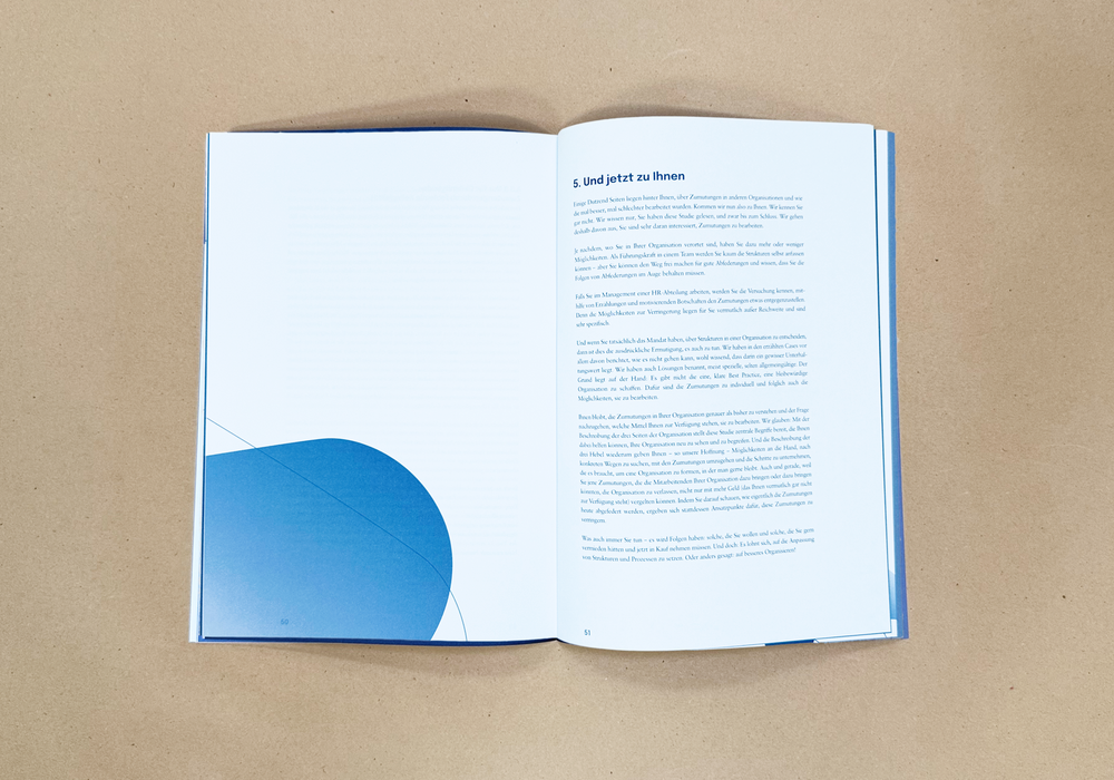 Das Bild zeigt ein aufgeschlagenes Buch mit blauem Einband und weißen Seiten, das auf einer braunen Oberfläche ruht. Das Buch scheint in deutscher Sprache zu sein, wie der auf den Seiten sichtbare Text zeigt. Das Buch trägt den Titel "G. und gesetz zu htenen" und wird als "Kinderbuch" beschrieben. Das Layout und die Gestaltung des Buches lassen darauf schließen, dass es sich um eine gedruckte Publikation handelt, die möglicherweise für junge Leser bestimmt ist.