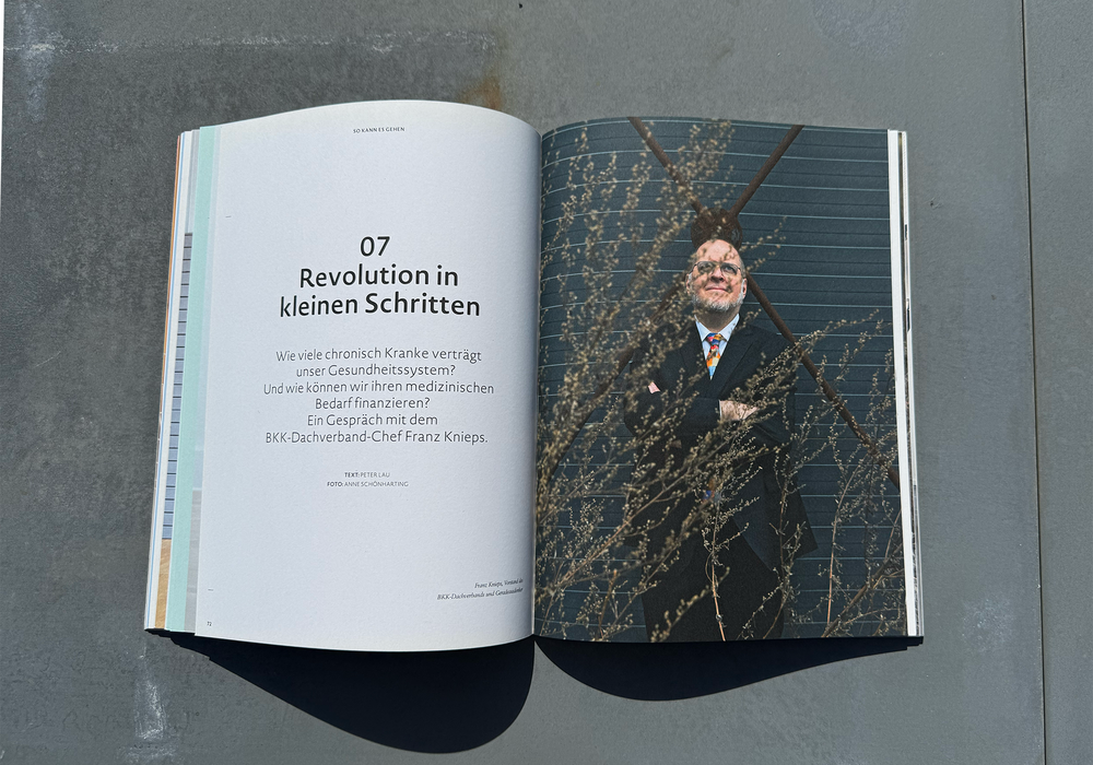 Das Bild zeigt ein aufgeschlagenes Magazin mit dem Foto eines Mannes, der vor einer Backsteinmauer steht, und einem Text auf der linken Seite, in dem das Konzept der "Revolution in Kleien Schriten" erläutert wird.