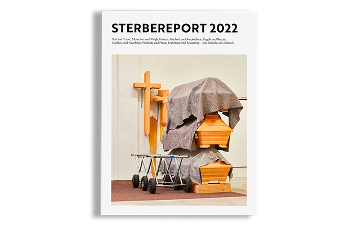 Das Bild ist das Titelblatt eines Berichts mit dem Titel "STERBERPORT" und zeigt ein Holzkreuz und einen Holzsarg auf weißem Hintergrund. Der Bericht scheint sich mit dem Friedhof in St. Petersburg, Russland, zu befassen und enthält eine Liste bedeutender Persönlichkeiten und ihrer Gräber. Die Umschlaggestaltung ist minimalistisch, mit einem sauberen weißen Hintergrund und einem schwarzen Rand.