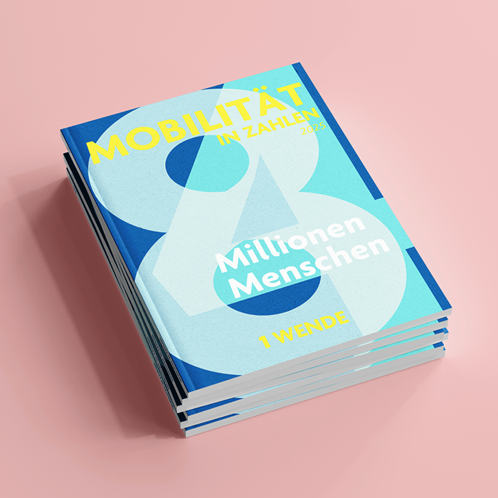 Das Bild zeigt einen Stapel von drei Büchern mit einem leuchtend blauen und gelben Einband. Die Bücher tragen die Titel "MÜBILITAT" und "MÜLLTEN" in gelber Schrift und "MÜLLTEN" in weißer Schrift. Auf dem Umschlag steht außerdem in gelber Schrift der Satz "1 WENDE". Die Bücher stehen auf einem rosafarbenen Hintergrund, was eine übliche Farbwahl für Buchumschläge ist, um sie hervorzuheben. Die Gestaltungselemente und das Farbschema deuten darauf hin, dass die Bücher wahrscheinlich für eine zugängliche Website bestimmt sind, die sich an ein breites Publikum richtet.