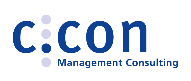 Das Bild zeigt das Logo einer Firma namens „C:CON Management Consulting“ in Blau und Weiß. Der Firmenname ist in großen blauen Buchstaben gut sichtbar dargestellt, wobei das Wort „C:“ über dem Haupttext positioniert ist. Unterhalb des Haupttextes steht in kleineren blauen Buchstaben der Ausdruck „Management Consulting“. Das Logo ist vor einem schwarzen Hintergrund platziert, wodurch es gut lesbar und optisch ansprechend ist.