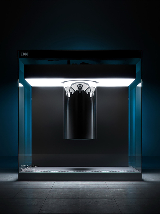 Das Bild zeichnet sich durch ein modernes, minimalistisches Design aus, in dessen Mitte ein elegantes Objekt in Schwarz und Silber platziert ist, das von einer hellen Lichtquelle beleuchtet wird. Das Objekt scheint eine zylindrische oder kugelförmige Struktur zu sein, möglicherweise ein Kunstwerk oder eine technologische Innovation. Der Hintergrund ist dunkel, was das Objekt und seine Details hervorhebt. Das Bild wirkt klar und aufgeräumt, wobei das Objekt im Mittelpunkt steht. Das IBM-Logo ist in der oberen linken Ecke zu sehen und weist auf die Marke des Objekts hin. Das Bild enthält weder Text noch weitere Objekte, und die Gesamtkomposition ist ausgewogen und optisch ansprechend.
