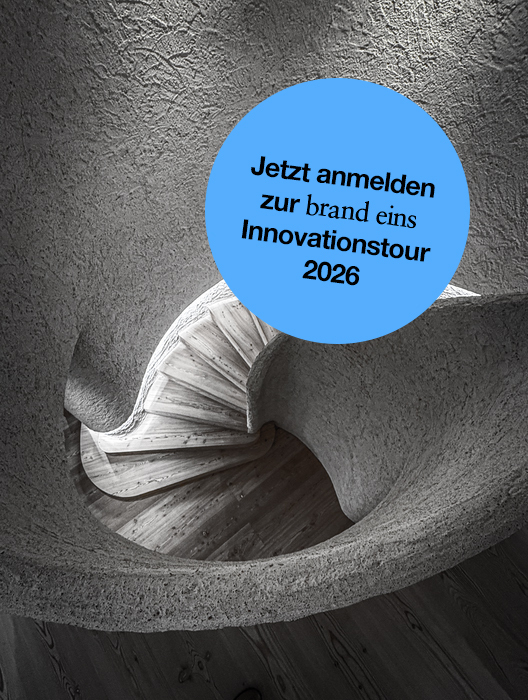 Das Bild zeigt eine Schwarz-Weiß-Fotografie einer Wendeltreppe, über die ein blauer runder Aufkleber gelegt ist. Auf dem Aufkleber steht auf Deutsch: „Jetzt anmelden zur brand eins Innovationstour 2026“. Das Bild wird als barrierefreie Website beschrieben, die dem Europäischen Gesetz zur Barrierefreiheit (EAA) entspricht, das die Verwendung von Alt-Text und Bildunterschriften für Bilder mit Text vorschreibt.