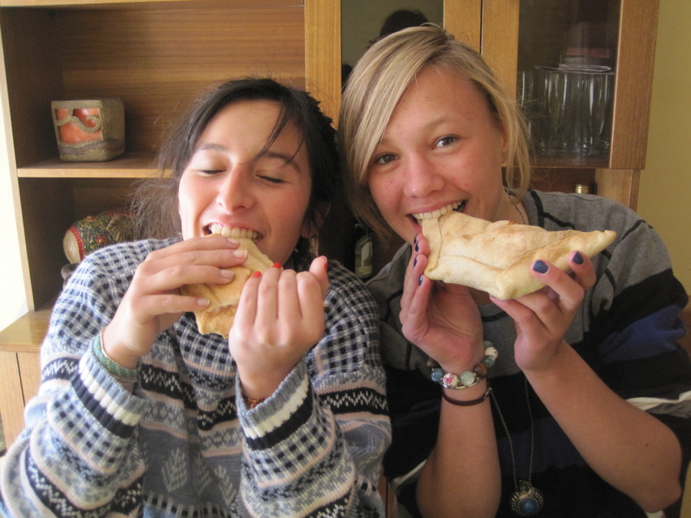 Austauschschülerin isst Empanadas mit Gastschwester in Chile