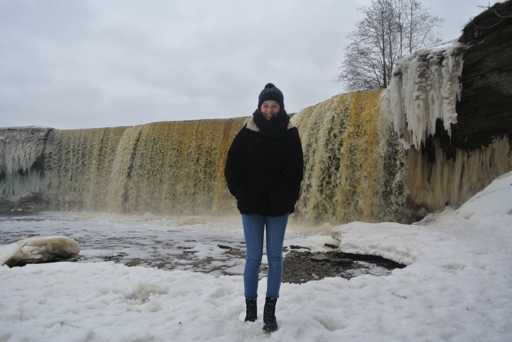 Austauschschülerin vor Wasserfall im Winter in Estland