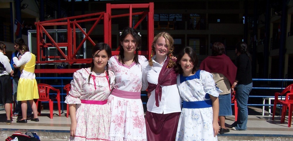 Austauschschülerin mit Freundinnen in traditionellen Kleidern in Chile