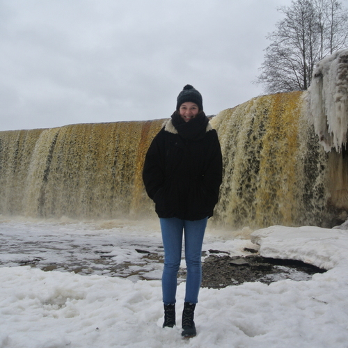 Austauschschülerin vor Wasserfall im Winter in Estland