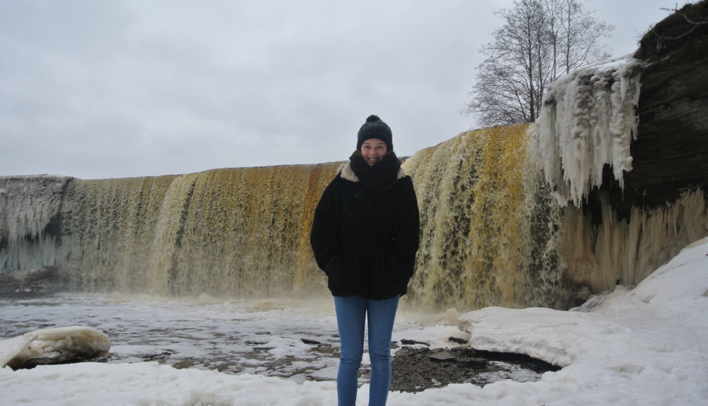 Austauschschülerin vor Wasserfall im Winter in Estland