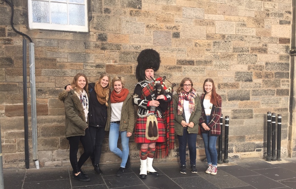 Austauschschülerin mit Freundinnen und Dudelsackspieler in Edinburgh