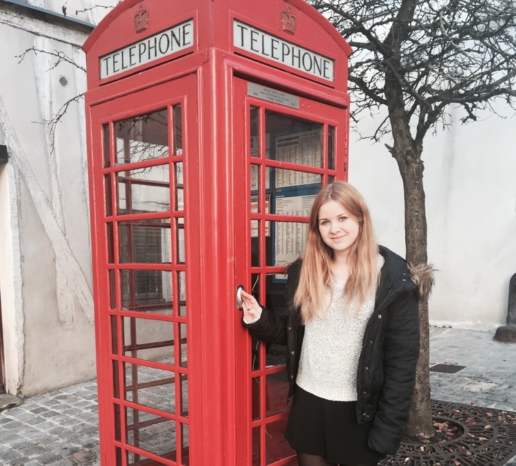 Austauschschülerin vor roter Telefonzelle in Großbritannien